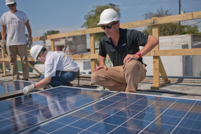 NRG President Crane installing solar in Haiti. Courtesy NRG. 
