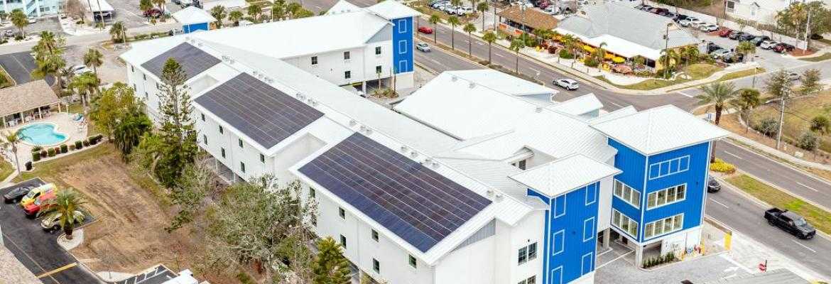 Aerial drone view of The J Hotel in Dunedin, Florida, featuring a completed solar panel installation by Solar Tech Elec, showcasing clean energy solutions in Florida