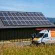 Large solar array on a vineyard rooftop with man exiting the Sunbridge Solar truck.
